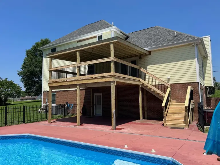 Covered second-story deck overlooking a pool and stamped concrete patio