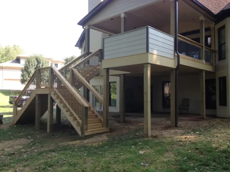 Covered deck with white railing and open staircase to the yard