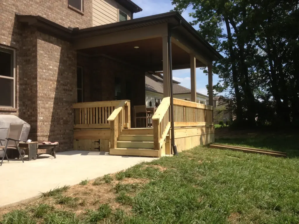Covered porch with pressure-treated deck, railing and steps to the yard
