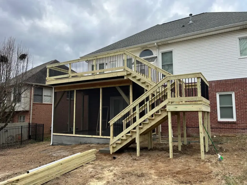 Elevated deck built above a screened porch with dual staircases