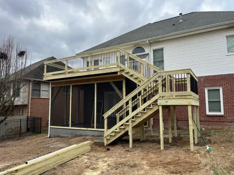 Elevated deck built above a screened porch with dual staircases