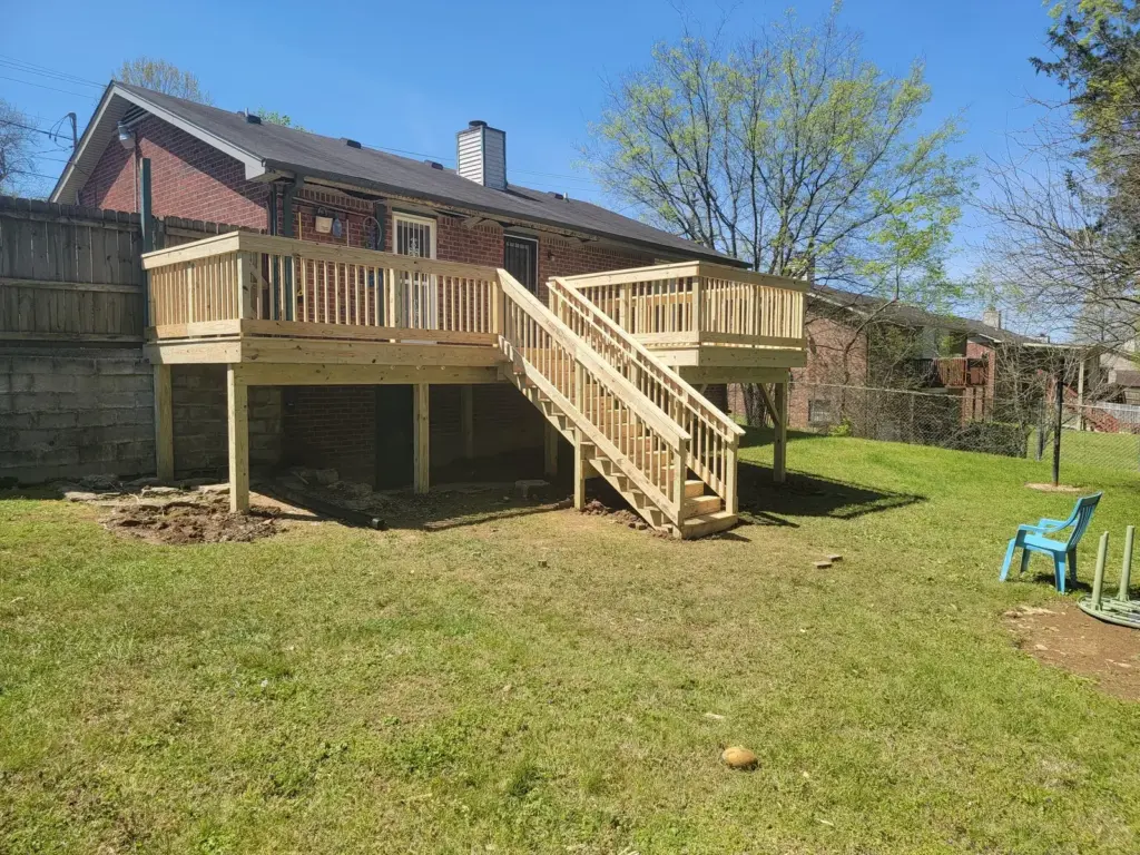 Elevated backyard deck in pressure-treated wood with open staircase