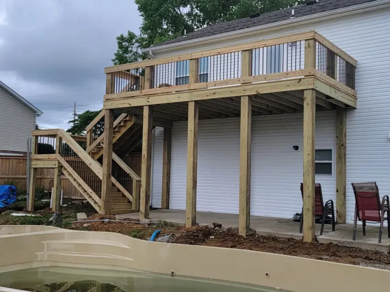 Elevated deck with black metal balusters beside an in-ground pool