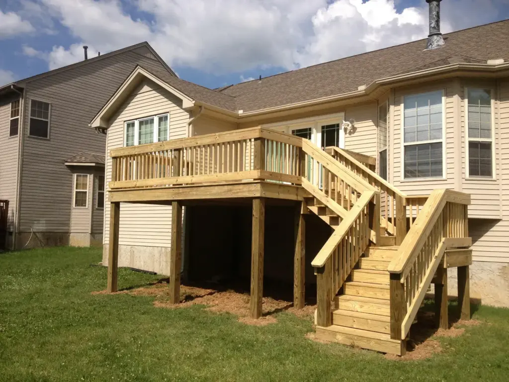 Elevated deck with wood railing and switchback stairs on a two-story home