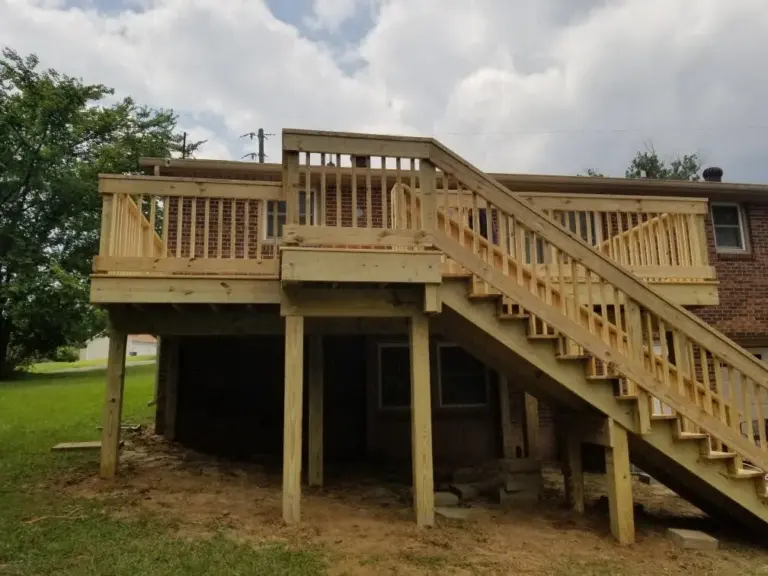 Elevated pressure-treated deck with long staircase to a sloped backyard