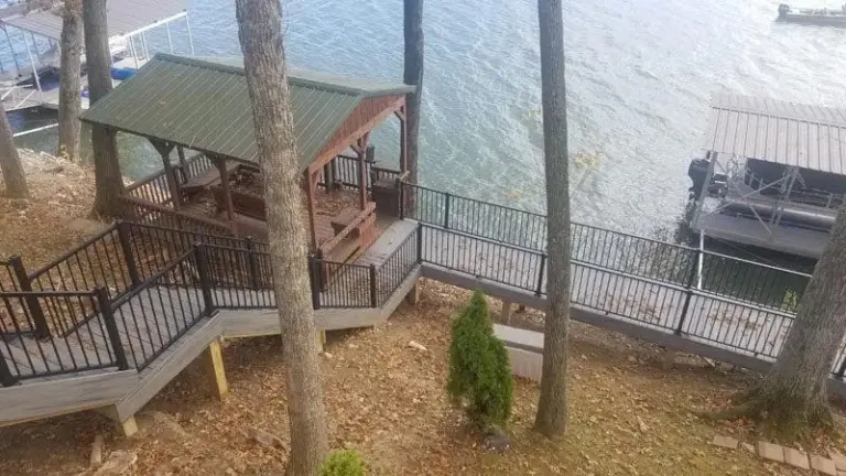 Composite deck and stairs leading down toward a covered lakeside dock