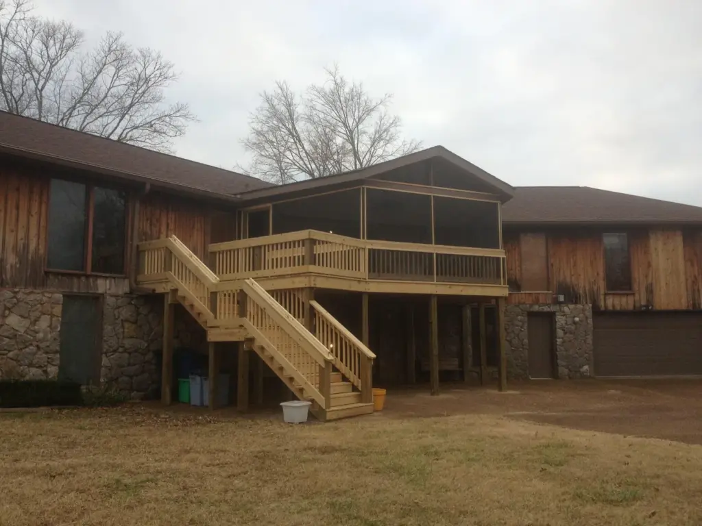 Screened porch with adjoining deck and pressure-treated staircase